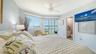 The primary suite offers an en suite bathroom and sliding door access to the enclosed lanai