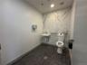 Bathroom with recessed lighting, dark tile patterned floors, and stone wall