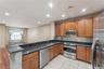 Kitchen featuring a breakfast bar with stone veneer detailing, dark granite countertops, and stainless steel appliances