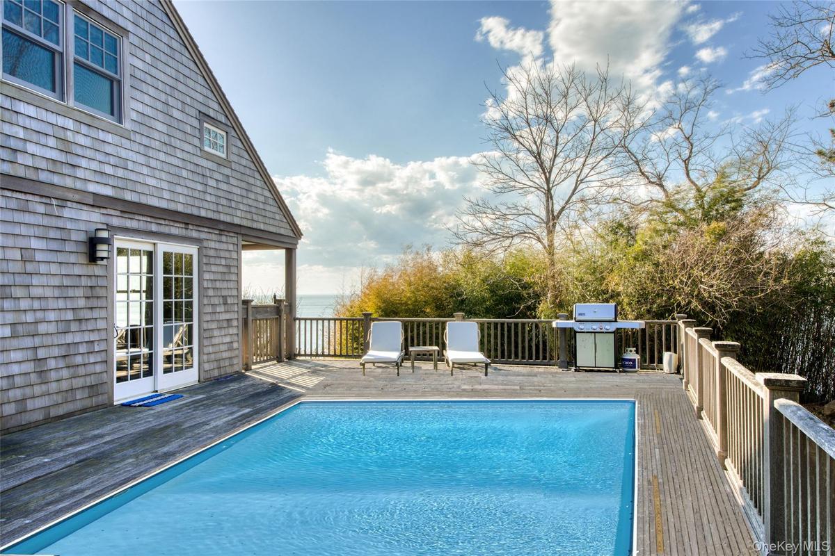 View of swimming pool featuring area for grilling and a wooden deck