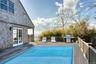 View of swimming pool featuring area for grilling and a wooden deck