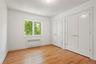 Unfurnished bedroom featuring two closets, radiator, and light wood finished floors