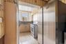 Kitchen featuring white gas stove, a sink, freestanding refrigerator, light brown cabinetry, and light tile patterned floors