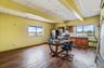 Office space with plenty of natural light, dark wood-type flooring, beamed ceiling, and a drop ceiling