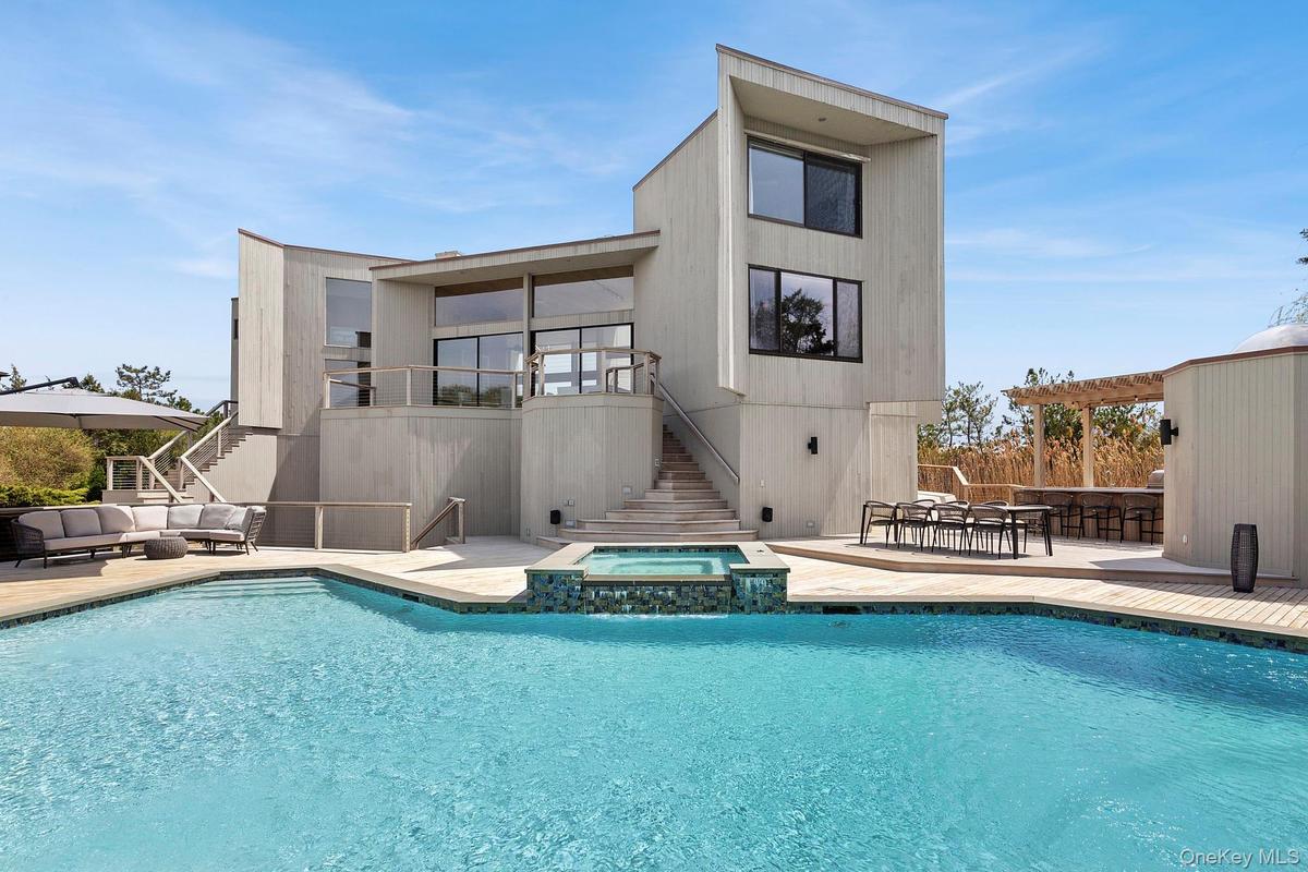 Rear view of property with stairway, a patio, an outdoor living space, and a pool with connected hot tub