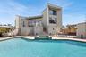 Rear view of property with stairway, a patio, an outdoor living space, and a pool with connected hot tub