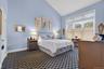Bedroom featuring high vaulted ceiling and dark carpet
