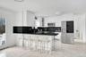 Kitchen with appliances with stainless steel finishes, tasteful backsplash, glass insert cabinets, a kitchen breakfast bar, and dark stone countertops