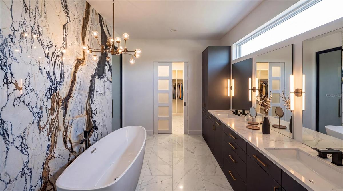Primary bath with dual vanities, gorgeous cabinetry, free standing tub and breathtaking feature wall. Large shower