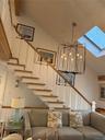 Living area featuring lofted ceiling, a skylight, and suspended lighting