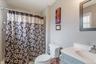 2 nd Floor Bathroom featuring a shower with tile surround, a built-in vanity with a white countertop and integrated sink, a framed mirror, and a toile