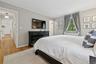 Bedroom featuring hardwood / wood-style flooring, a baseboard radiator, and crown molding