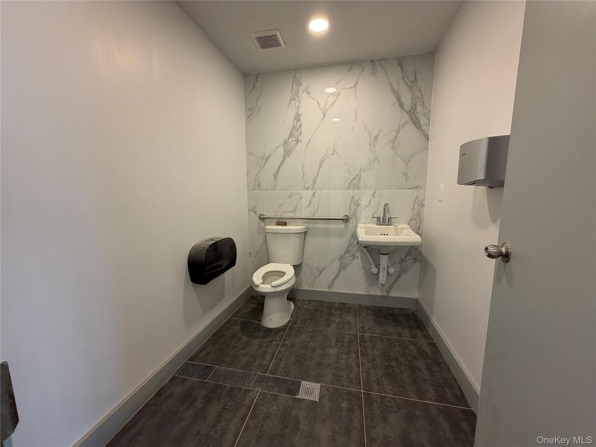Bathroom featuring recessed lighting and dark tile patterned flooring