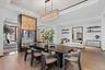 Dining area with a raised ceiling, light wood-style flooring, and a notable chandelier