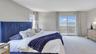 Carpeted bedroom with access to outside and a water view