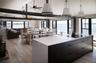Kitchen featuring modern cabinets, decorative light fixtures, light wood-style flooring, open floor plan, and a water view