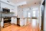 Kitchen with stainless steel appliances, pendant lighting, a peninsula, white cabinetry, and open floor plan