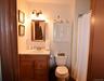 Bathroom vanity with light-tone countertop and wood-finish cabinetry