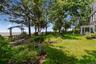 View of grassy yard featuring a water view and a patio