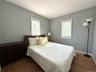 Bedroom featuring wood finished floors and multiple windows