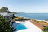 View of pool featuring fence, a fenced in pool, a patio, and a deck with water view