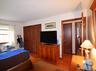 Room featuring hardwood flooring, white walls, and wood trim