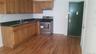 Kitchen featuring stainless steel electric range oven, dark countertops, brown cabinets, and dark wood-type flooring