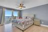 Bedroom with access to outside, a water view, light wood finished floors, and ceiling fan