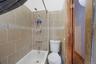 Bathroom with shower / bathtub combination and tile walls