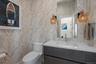 Half bathroom with wallpapered walls and vanity