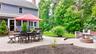 Expansive paver patio featuring a built-in fire pit, multiple seating areas, and direct access to the home