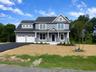 Beautiful new construction ready for occupancy, showcasing the home's completed exterior, welcoming covered front porch, two-car garage and modern arc