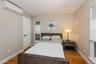 Bedroom featuring a wall mounted AC and light wood-style floors