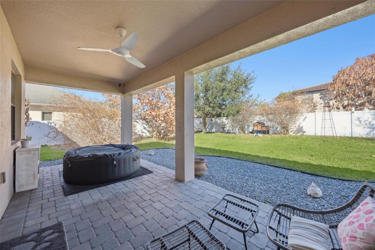 Large covered paved lanai overlooks the fully fenced backyard