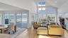 Living area with high vaulted ceiling, a skylight, light wood-style floors, and recessed lighting