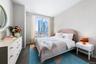 Bedroom with a view of city and dark wood finished floors