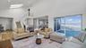 Living area featuring a wealth of natural light, high vaulted ceiling, a water view, and a skylight
