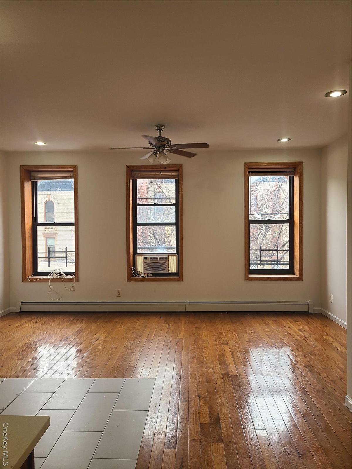 Spare room with cooling unit, recessed lighting, baseboards, hardwood / wood-style flooring, and a ceiling fan