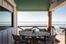 Balcony featuring outdoor dining area and a water view