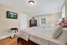 Bedroom featuring light wood finished floors, radiator heating unit, and vaulted ceiling