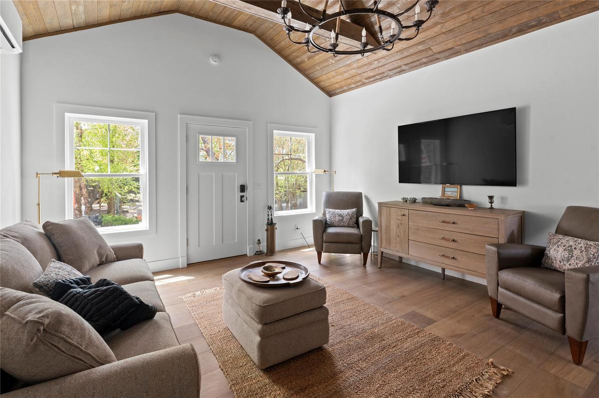 Living area featuring wood ceiling, a chandelier, lofted ceiling, and wood-type flooring