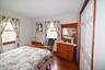 Light-filled room featuring wood-finish flooring, two large windows, painted walls, and a bi-fold closet door with wood trim