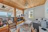 Living area featuring a natural wood plank ceiling, exposed wood beams, and warm wood-finish flooring