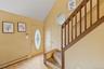 Foyer with baseboard heating, stairway, light wood finished floors, and high vaulted ceiling