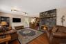 Living area featuring a stone fireplace with a wood mantle, wood-finish flooring, and recessed ceiling lighting