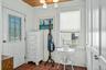 Entry area featuring terracotta-style tile flooring, a wood-paneled ceiling, and a white paneled door with decorative glass