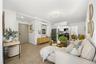 Living area with baseboards, light wood-style flooring, and a wall mounted AC
