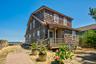 Two-story shingle-sided residence featuring a covered front porch with wood railings
