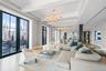Living area featuring a notable chandelier, baseboards, beamed ceiling, and crown molding