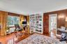 Guest bedroom (being used as an office) with wood floors, crown molding and built-in bookcases
